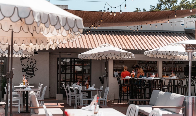 Restaurant patio with tables, chairs, umbrellas, outdoor bar and lights