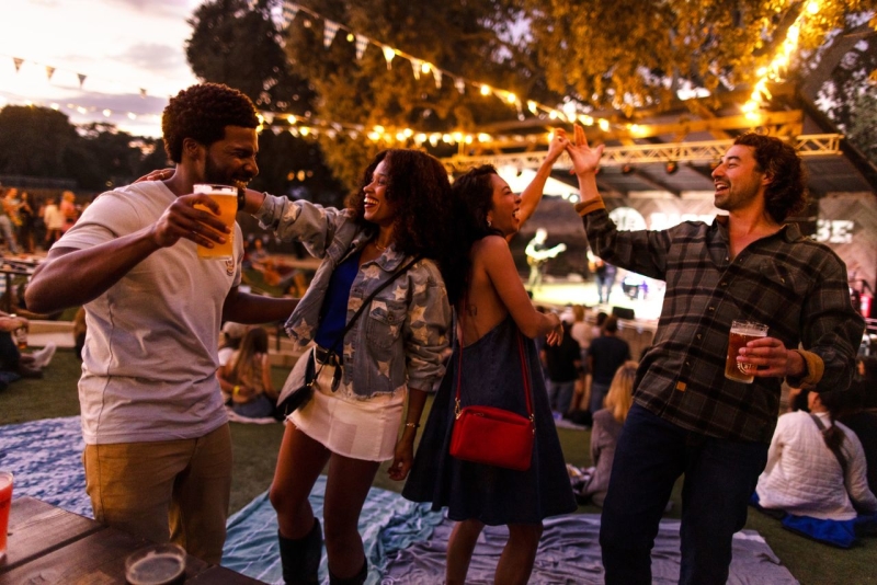 Group of friends dancing under twinkling lights at a live music venue