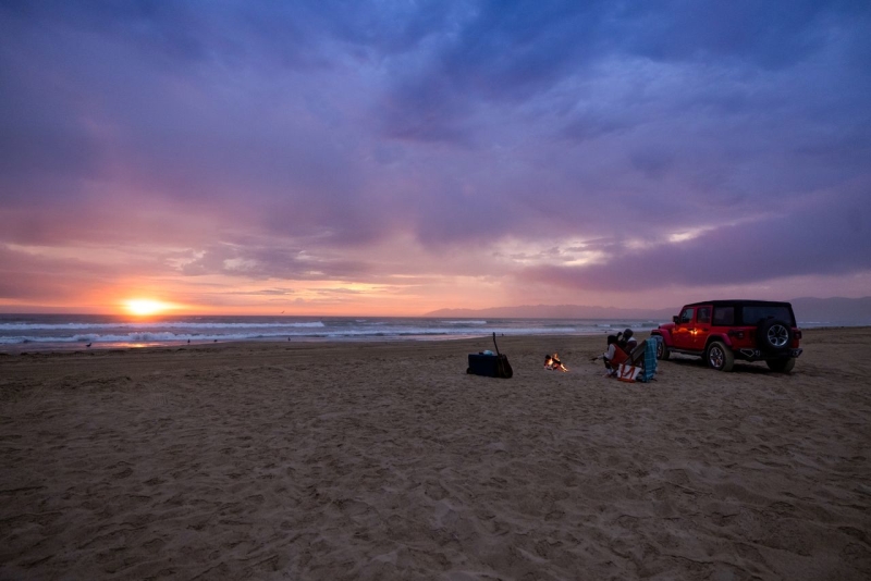 Couple having a beach bonfire in Pismo Beach, CA