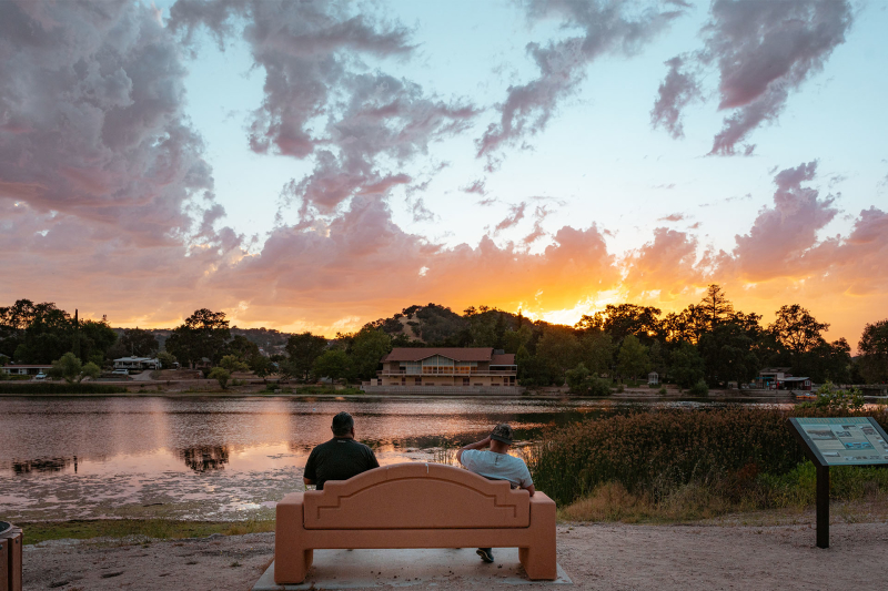 People sitting on bench at Atascadero Lake Park