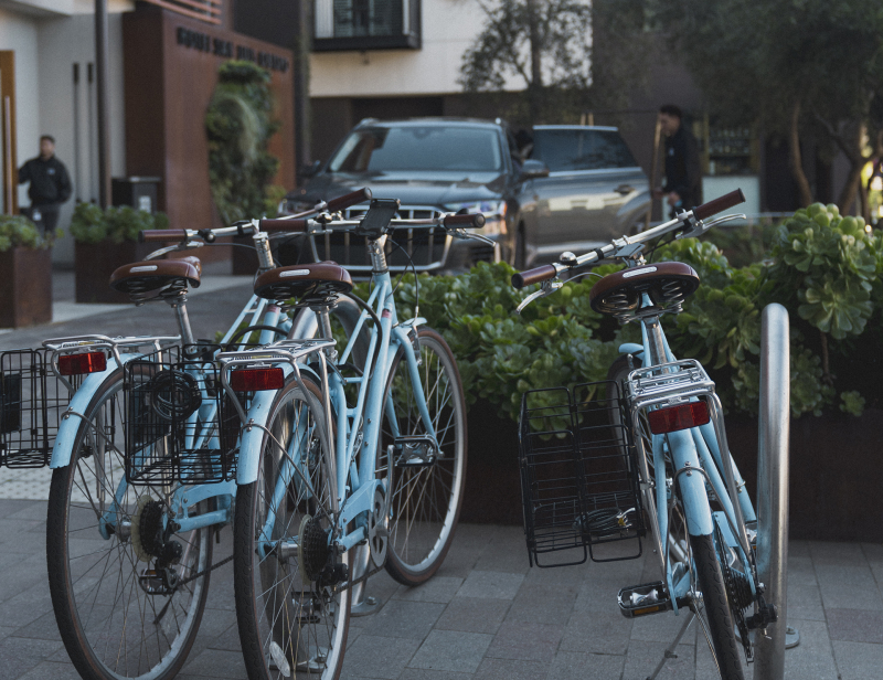Bike rack with three blue bikes outside of Hotel San Luis Obispo