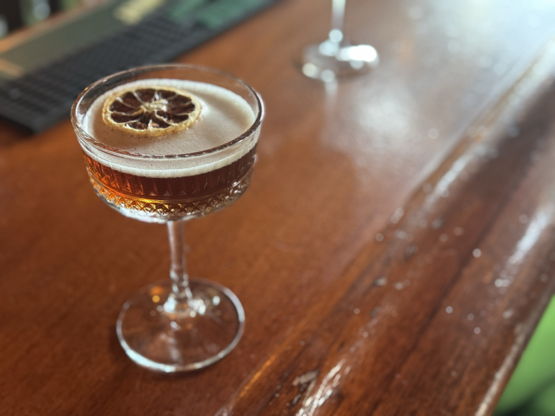Espresso Martini cocktail in a coop glass on a wooden bar at Feral in downtown San Luis Obispo