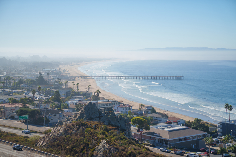 View of cloud cover, coast-line and pier from above
