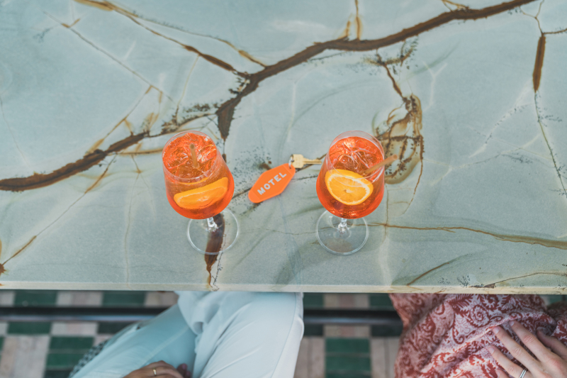 Image of two Aperol spritz with a motel key on a bar