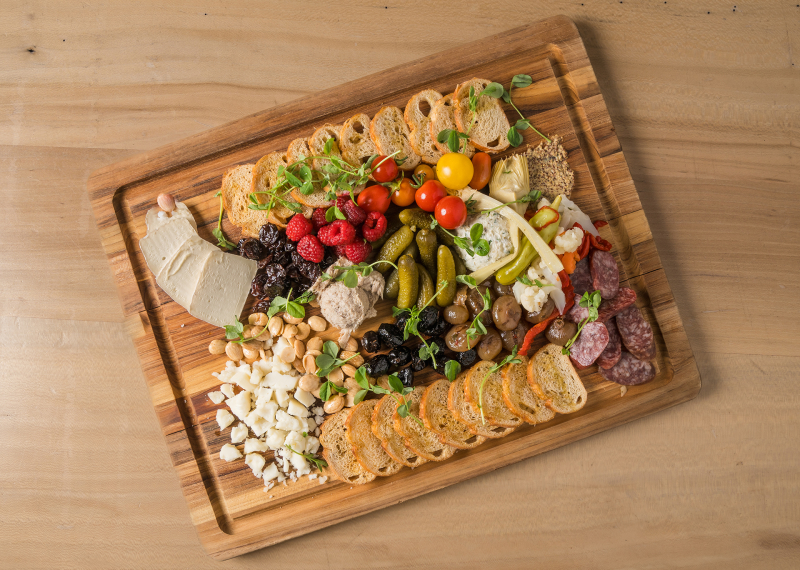 Flat lay of charcuterie board on wooden tray on wooden table