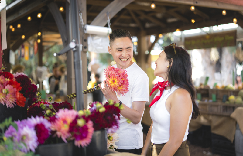 Couple smiling and picking out colorful flowers