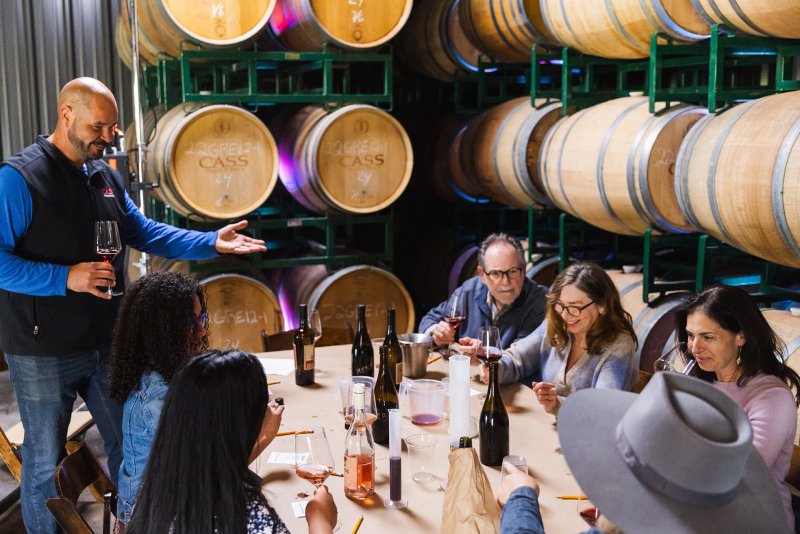 People sitting at table drinking and mixing wine