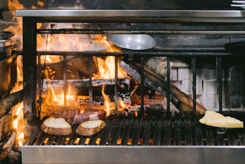 Bread and meat cooking on open grill