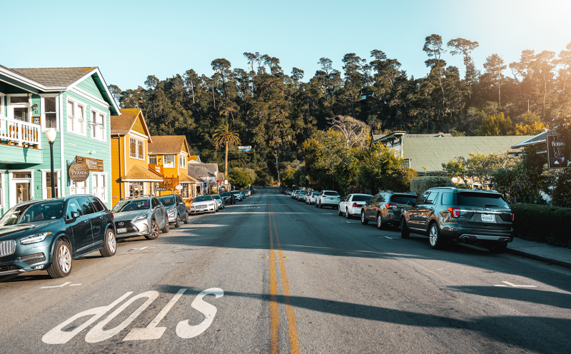 Streetscape of road in Cambria with shops and cars along the road with pines in the background