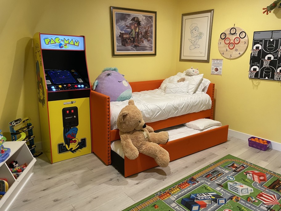 Kid room with 2 twin beds and lots of books and toys