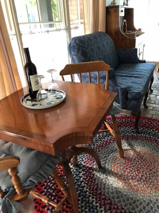 Sitting area with love seat, table for two with wine.