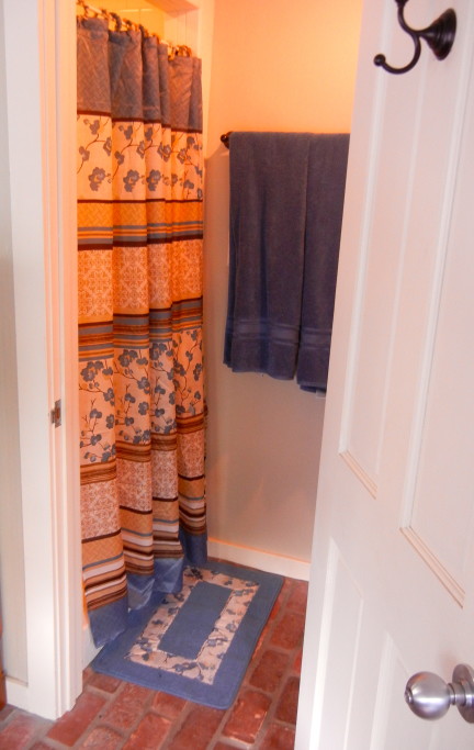 Bathroom with tiled shower & commode.