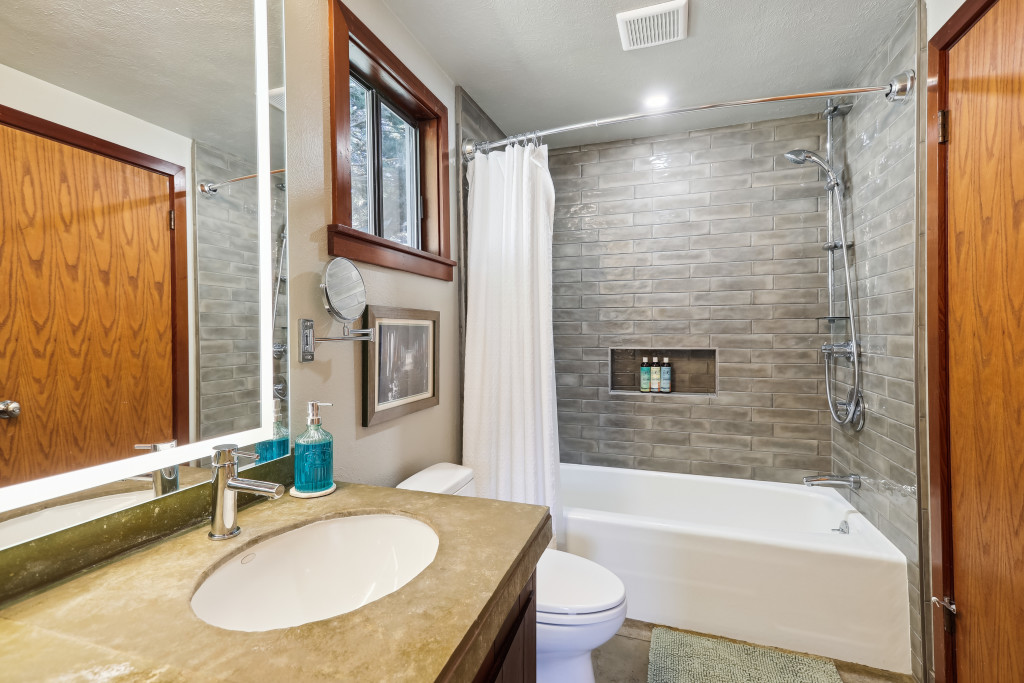 Hall bathroom with a shower over tub and heated floors
