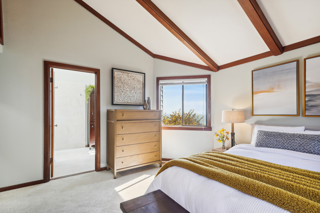 The primary bedroom has a private bathroom and window views of the ocean.