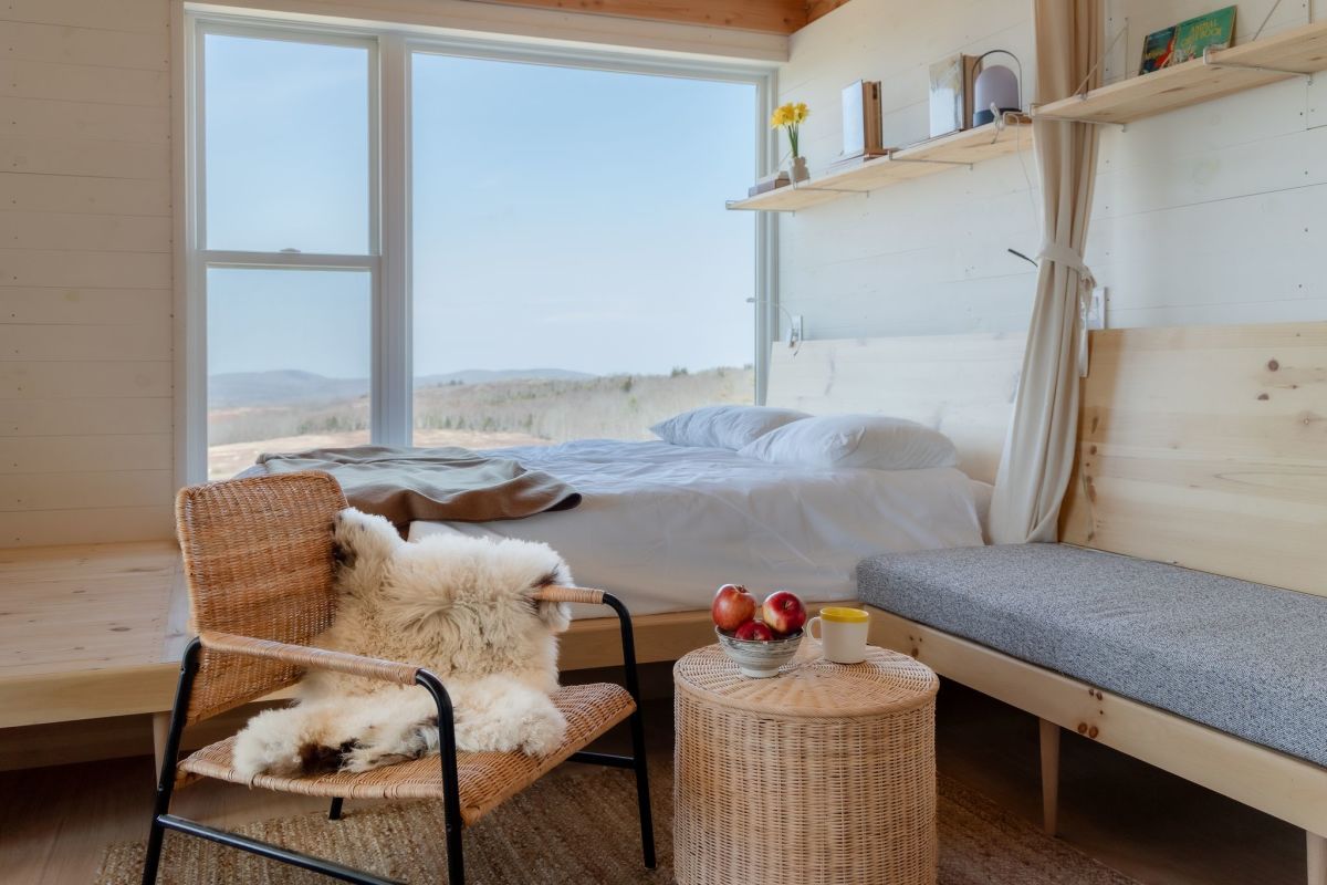 Open-plan cabin dining and lounge spaces built using natural materials like local sustainable wood insulation from Maine-based TimberHP.