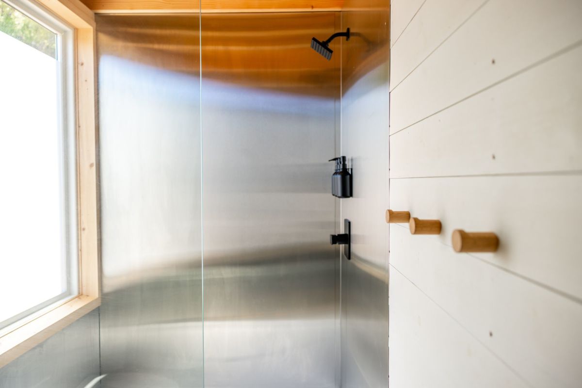 A bright cabin bathroom featuring custom tiling, modern fixtures, and window placement that floods the space with natural light.