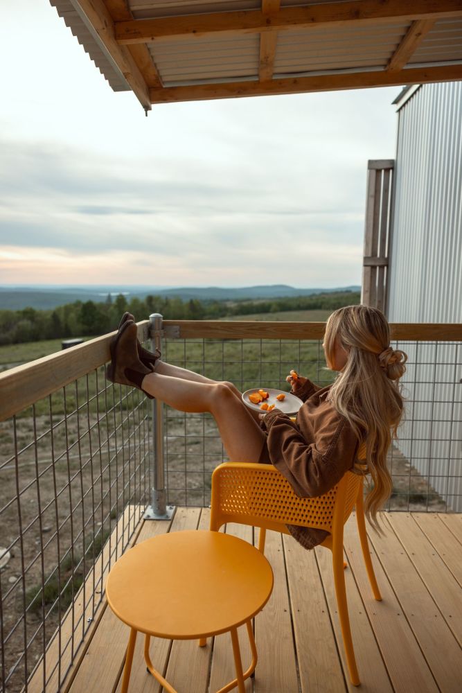 A guest relaxing on a private wood deck, enjoying quiet moments with coffee and overlooking the wild lowbush blueberry field.