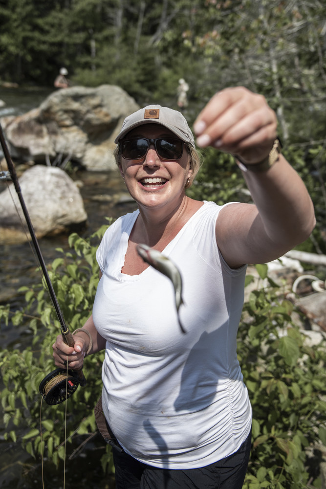One of our New England Fly Company clients holding up her first ever caught fish, a juvenile smallmouth bass, caught on a hot summer day from the Presumpscot River in Windham.