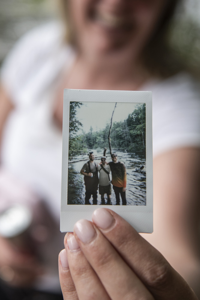 A New England Fly Company client holds up a polaroid she took with our guides after a successful guided summer fly fishing trip near Portland.