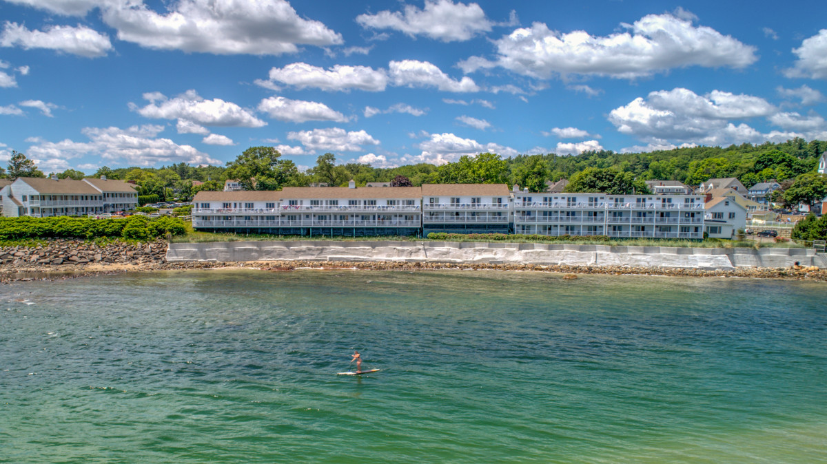 Oceanfront exterior of The Sparhawk Oceanfront Resort overlooking the sandy shoreline of Ogunquit Beach.