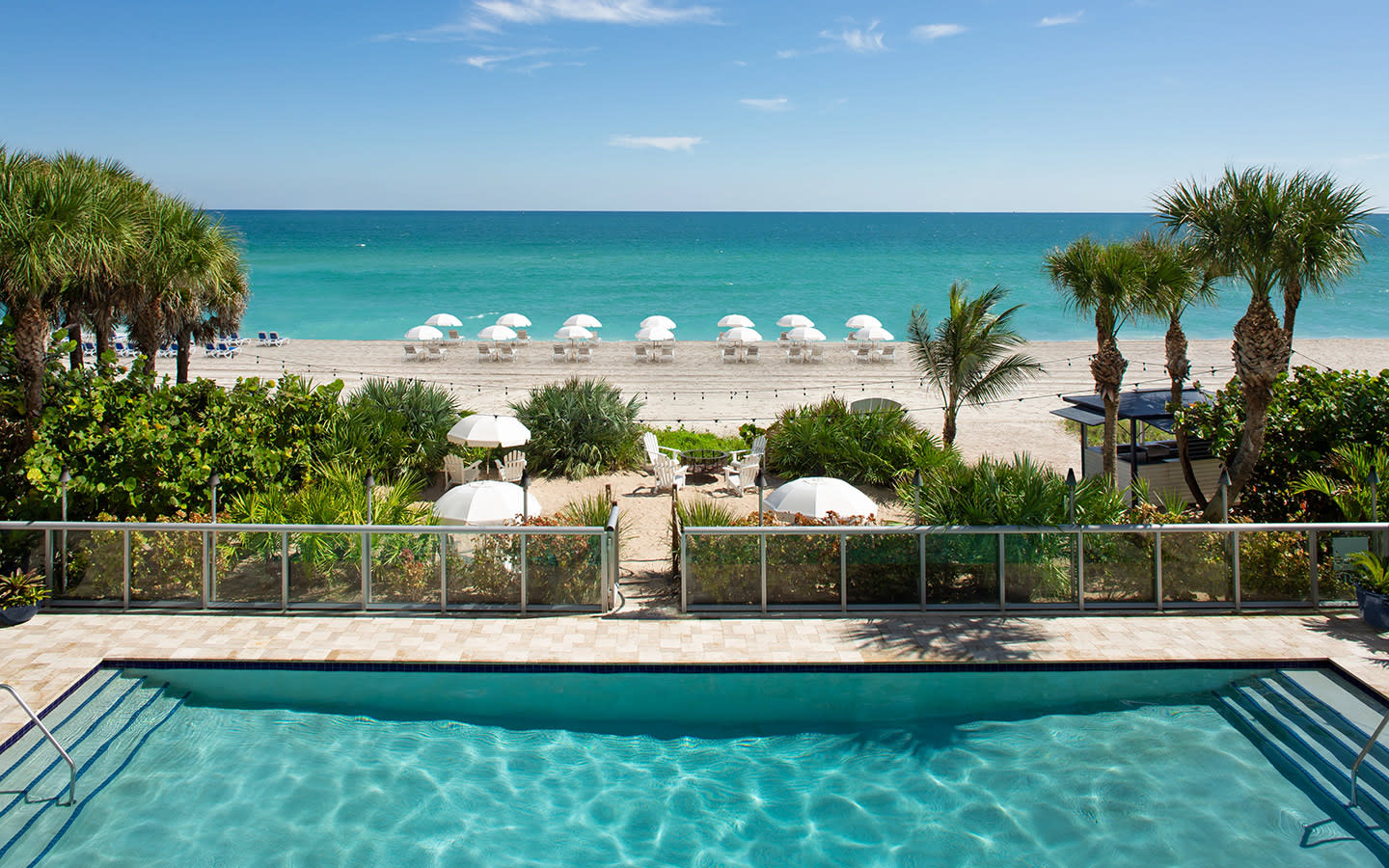 Relax in the sunshine at our beachfront pool, just steps from azure waters and the white sand beaches of Sunny Isles.