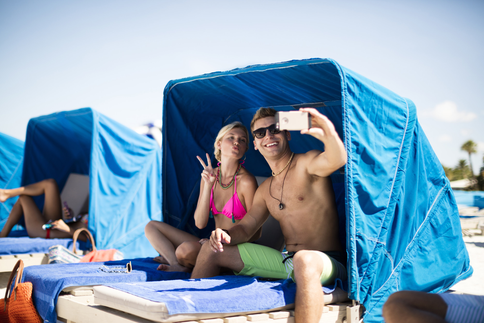Relax on a cushioned beach cabana for two