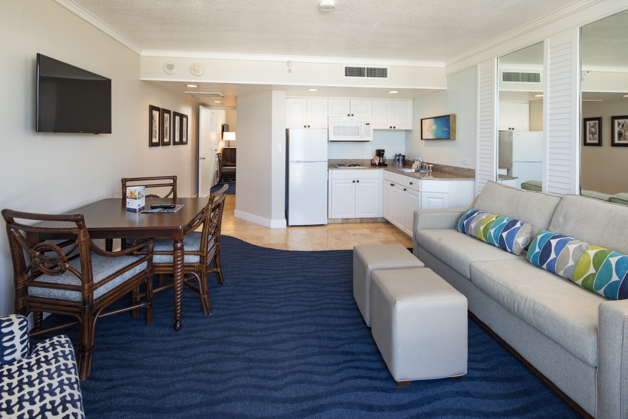 Kitchenette with full-size fridge, microwave, coffee maker, toaster and dishware.