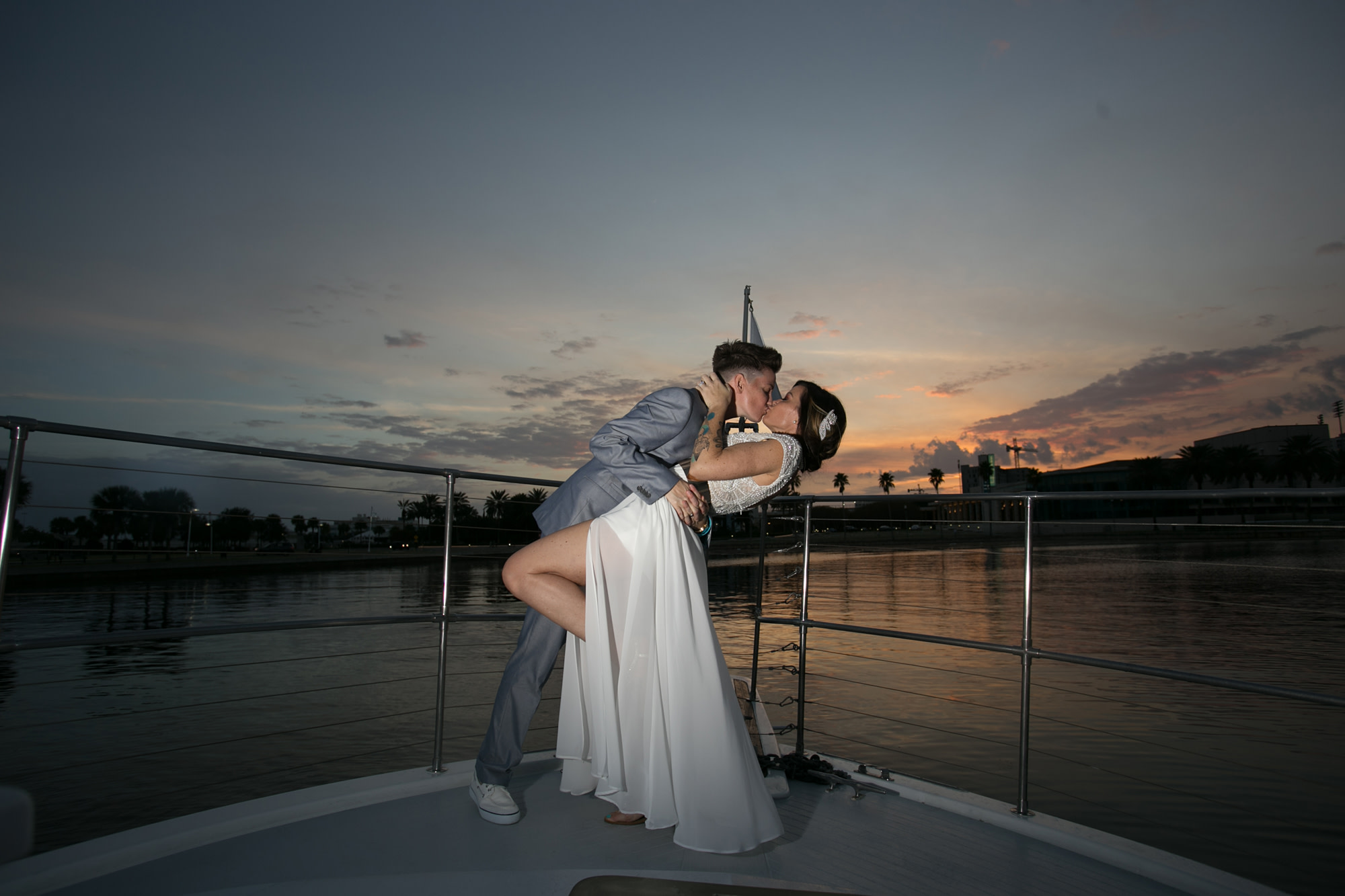 Couple kissing on bow of boat after getting married.