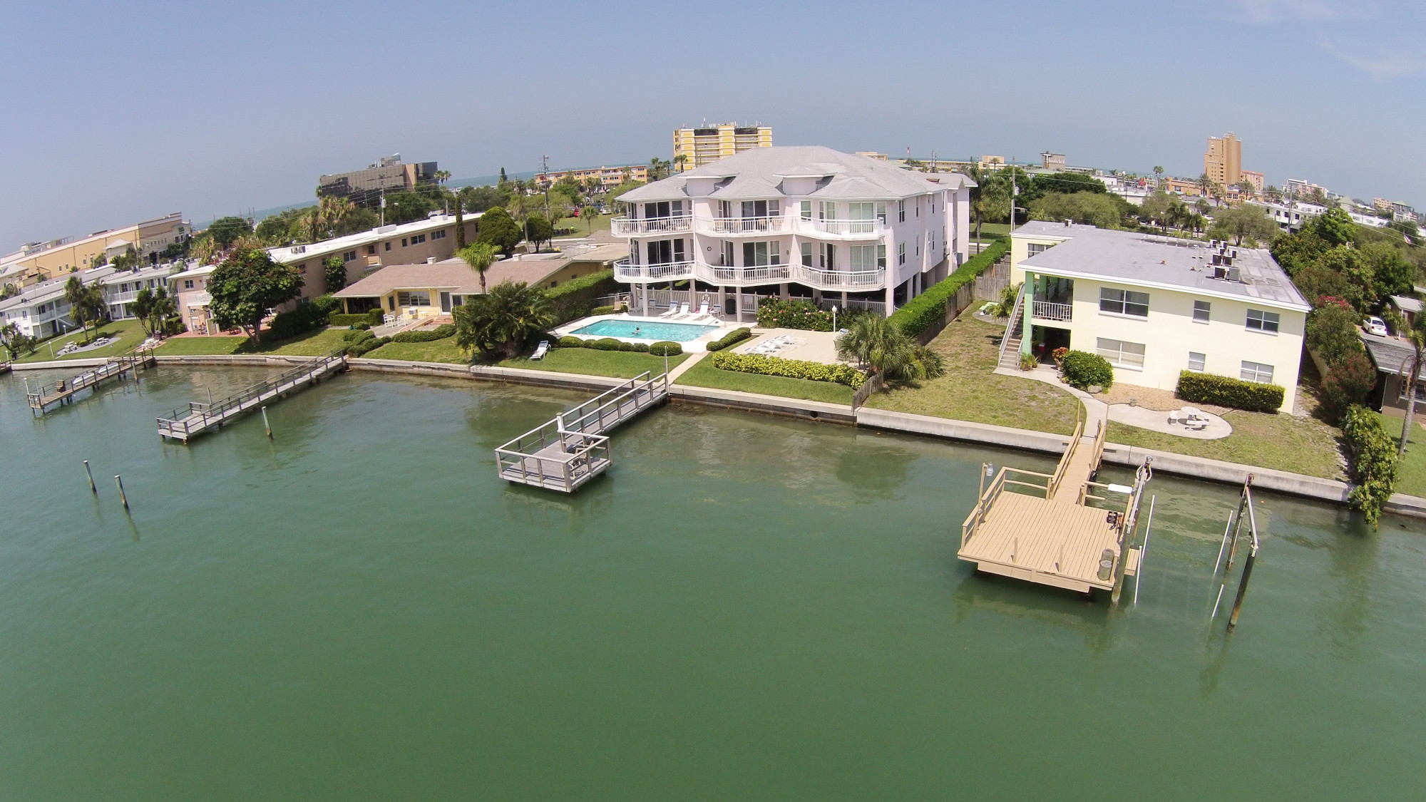 A 2-story waterfront condo building with a pool and parking beneath