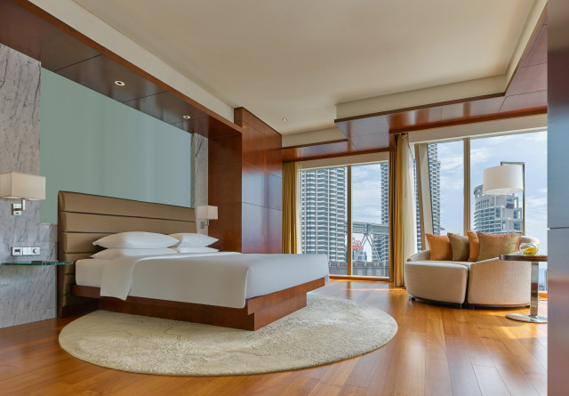 Grand Suite - Bedroom - Immerse in 105 sq m suite with one king bed and either city or twin towers view, living room, luxurious bathroom fitted with oval-shaped marble bathtub and Grand Club lounge access.
