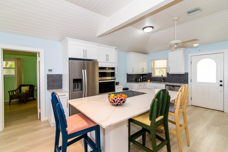 Kitchen has eat in counter top with 3 bar stools