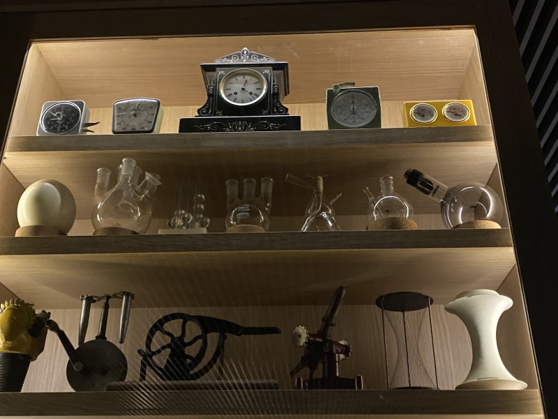                         The Cabinet of Curiosities at the Heartwood features glass-encased shelves adorned with antique clocks, scientific equipment and other artifacts for Vassar College's history.
                        