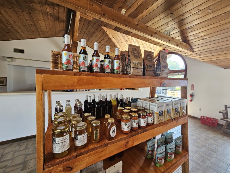                         Shelves lined with jars and bottles of local products for sale at The General's Gathering in Millbrook.
                        