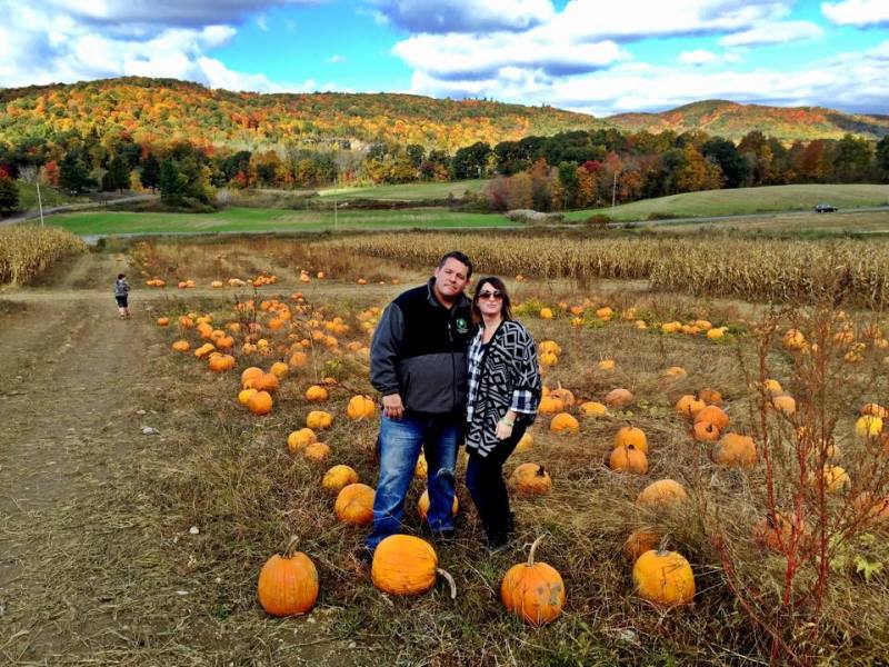                         A man and a women stand arm in arm in a pumpkin patch on an autumn day at Dykeman Farm in Pawling.
                        