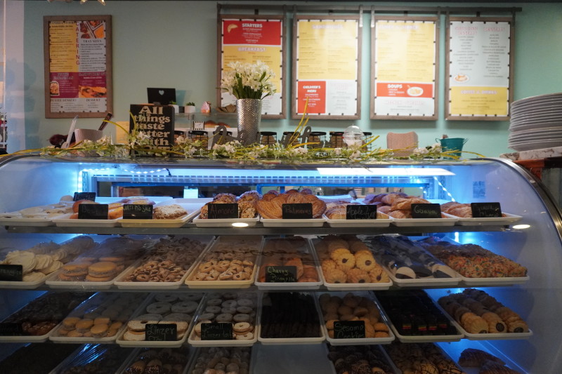                         Cookies sit in a display case in front of the food menu
                        