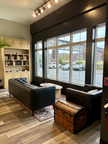                         A cozy nook inside Anna et Pierre Le Cafe with sofas and a large window.
                        