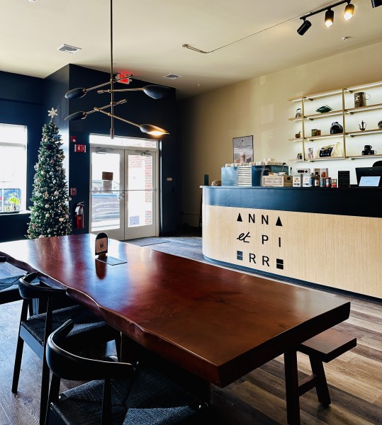                         The interior of Anna et Pierre Le Cafe with a rectangular wooden table and chairs.
                        