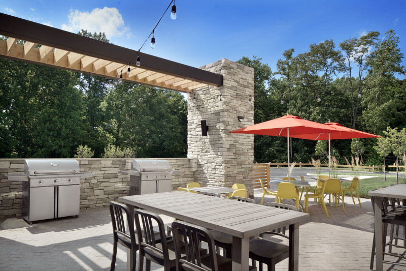                         The barbecue patio with tables, chairs, umbrellas and a grill at Home2 Suites.
                        