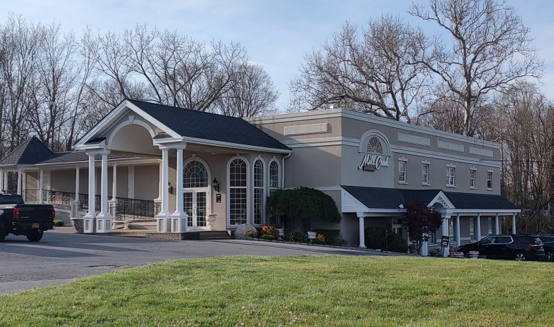                 A photo of Mill Creek Catering in Hopewell Junction, with its gray exterior and white columns.
                