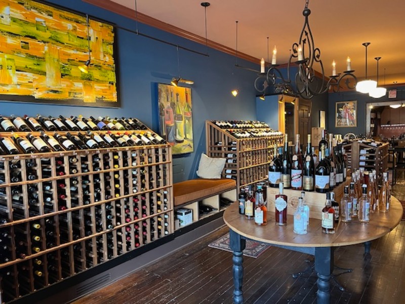                         Colorful paintings hang on the blue walls lined with shoulder-high racks of bottles at Millerton Wine & Spirits.
                        