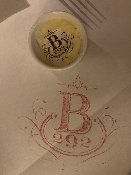                 A white tablecloth with the Brasserie 292 logo in red
                