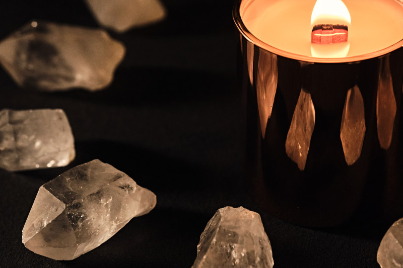                         Candle burning surrounded by crystals.
                        