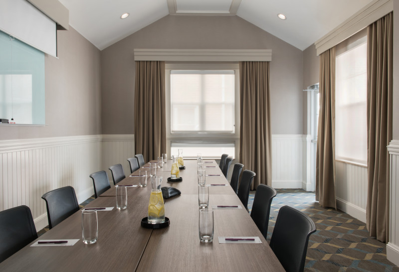                         A conference room at the Residence Inn by Marriott Poughkeepsie with a long table with chairs set up on both sides and water glasses.
                        