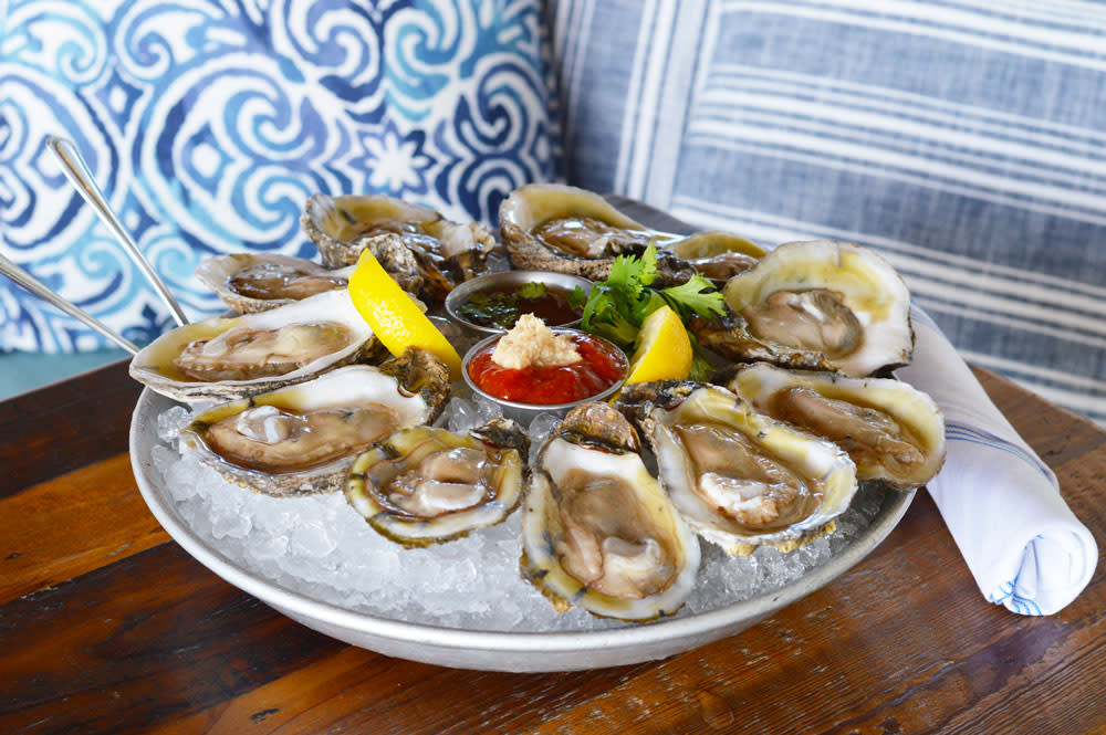 Fresh oysters on a platter with lemon and sauce