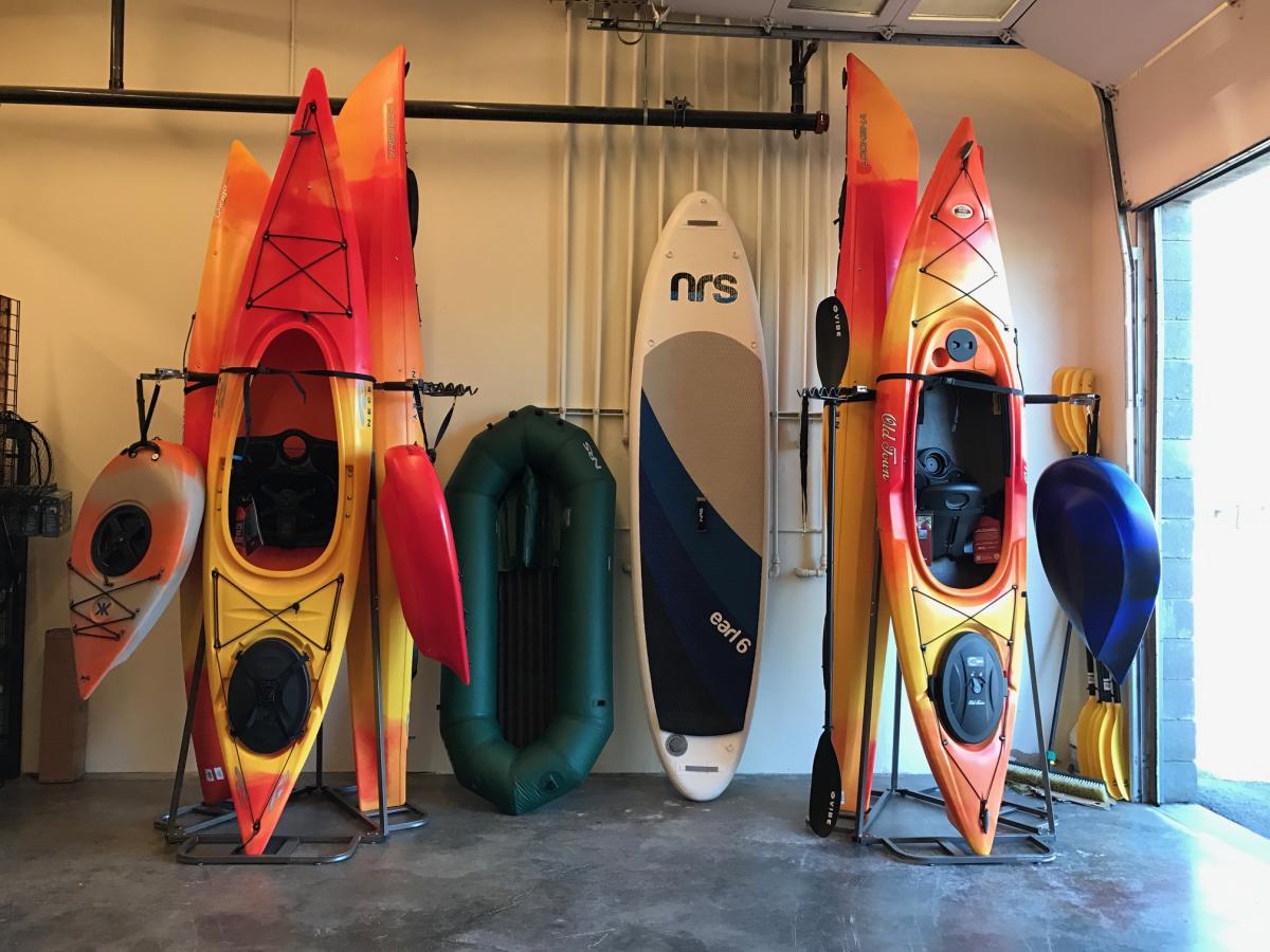 Professional outdoor gear rental operation showing organized kayaks and equipment ready for adventure rentals