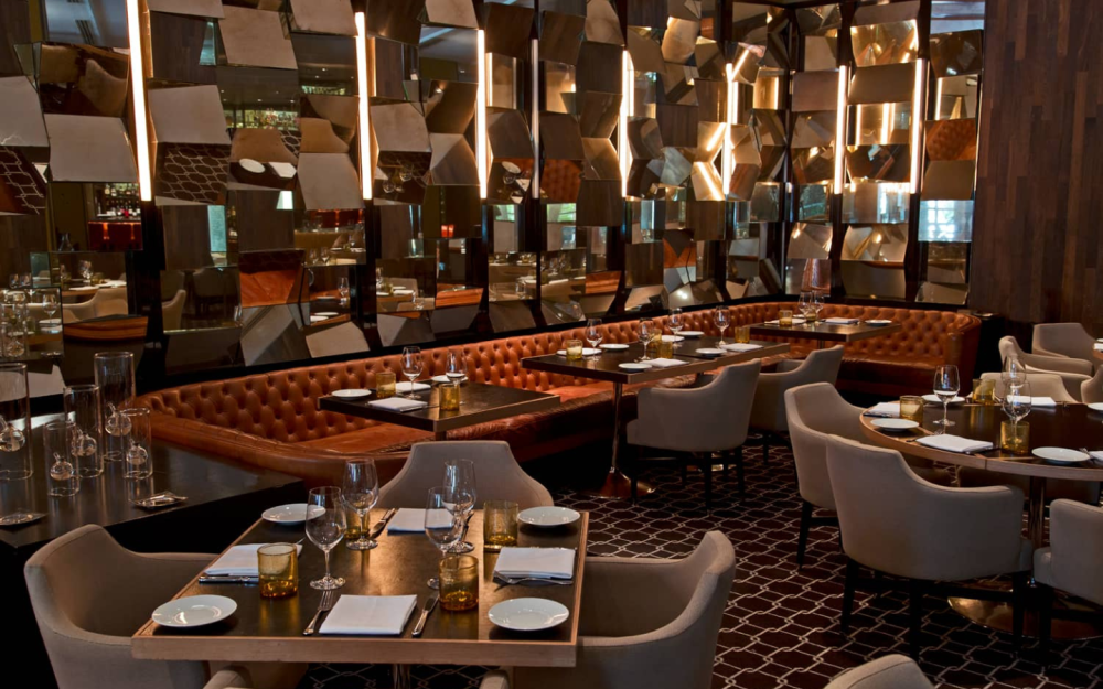 Bourbon Steak Miami offers diverse seating options, including standard chairs, booths, glass boxes, and private dining areas.