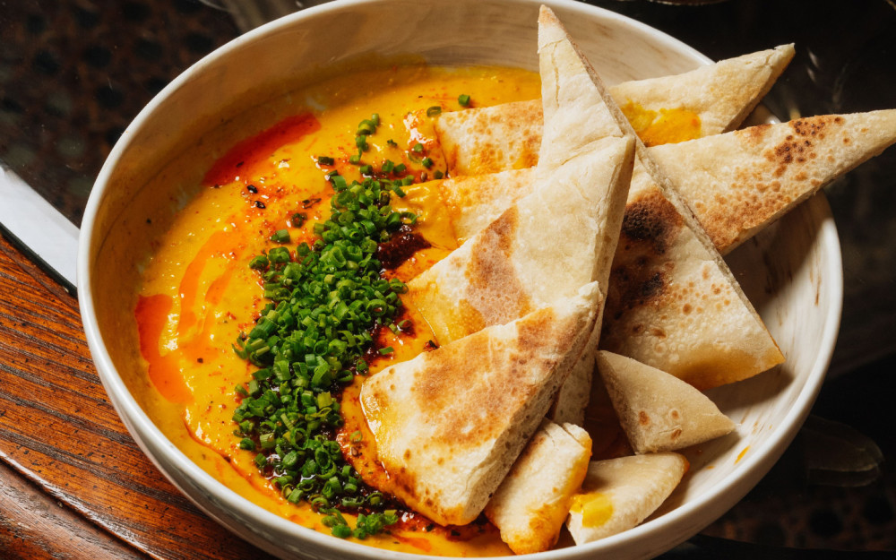 Hummus aus gerösteten Guajillo- und Piquillo-Paprikaschoten, serviert mit Pita.