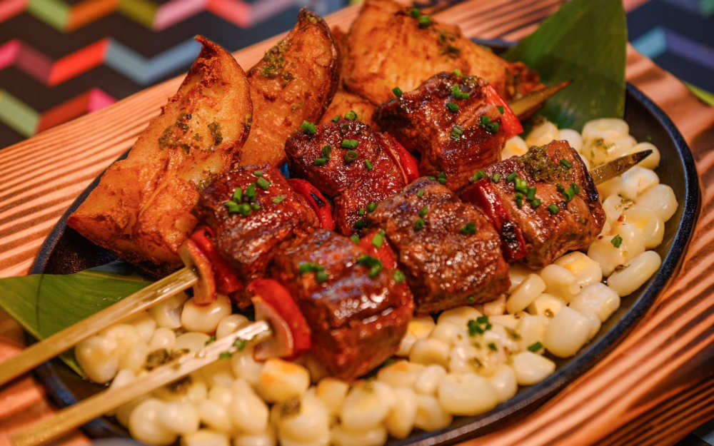 Anticucho de Carne: grilled beef skewers, roasted potatoes, Peruvian corn, rocoto & huacatay herb sauces
