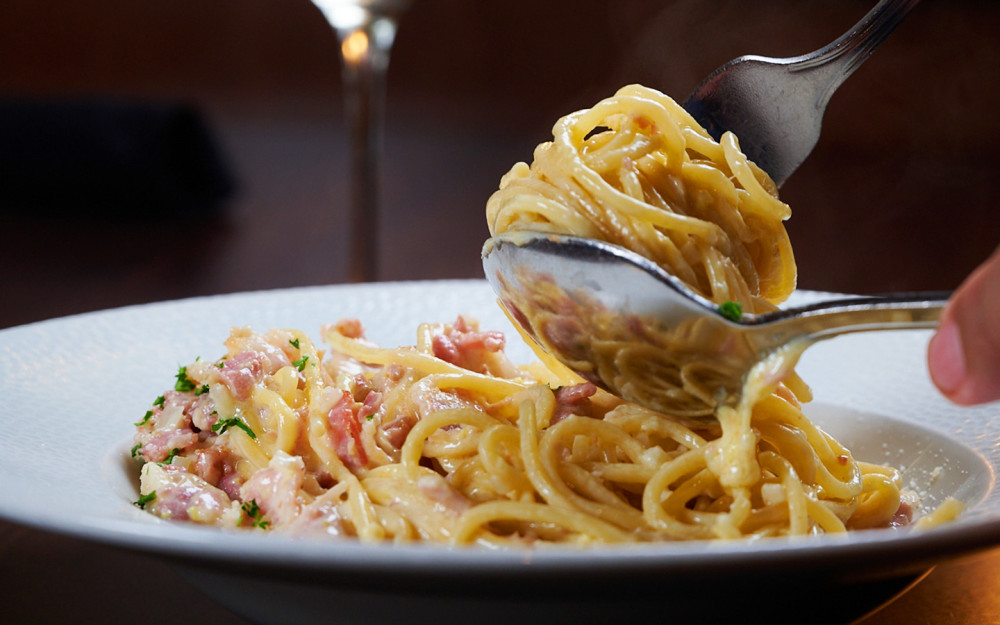 Комфортная еда прямо к вашему столу. Паста спагетти с панчеттой, яичным желтком и черным перцем в сливочном соусе Пармиджано Реджано.