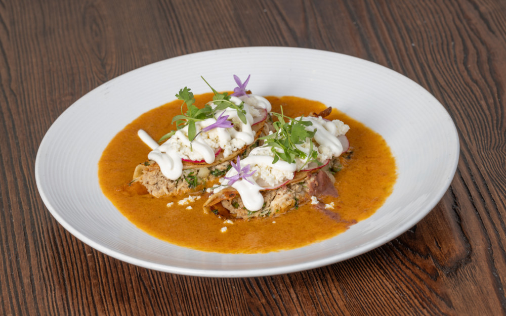 Tortilhas de milho, molho de enchilada, purê de feijão vermelho, creme mexicano, quest fresco